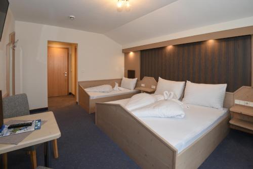 a hotel room with two beds with white pillows at Golf & Skipension Krug in Haus im Ennstal