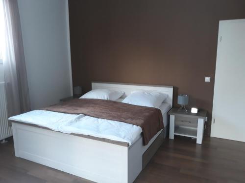 Un dormitorio con una gran cama blanca y una mesa en Finkennest, en Annweiler am Trifels