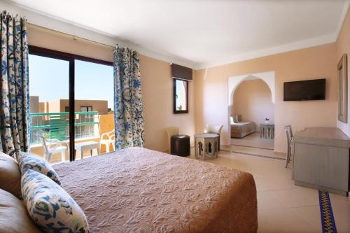 a bedroom with a bed and a view of a balcony at Valeria Madina Club - All Inclusive in Marrakech