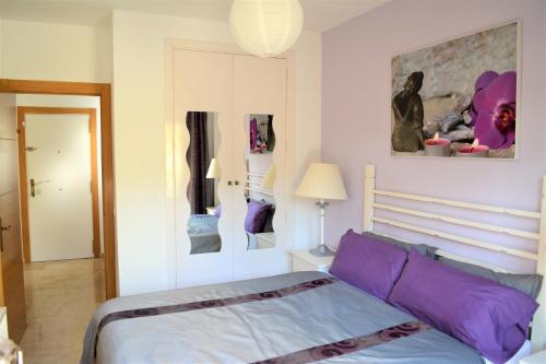 a bedroom with a bed with purple pillows at LA FLORIDA in San Luis de Sabinillas