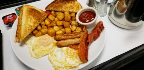 a white plate of breakfast food with eggs bacon and toast at Deerfoot Inn and Casino in Calgary