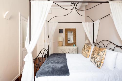 a bedroom with a white bed with a black frame at SuityRHome RioneMonti56 in Rome