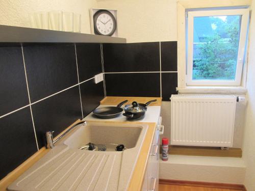 a kitchen with a sink and a clock on the wall at Sapana in Pockau