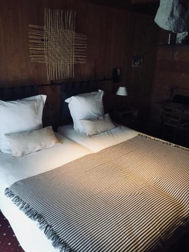 a large bed with white sheets and pillows at Le Coin Savoyard in Combloux