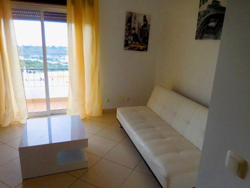 ein Wohnzimmer mit einem weißen Sofa und einem Fenster in der Unterkunft Vista Albufeira Apartments by Umbral in Albufeira