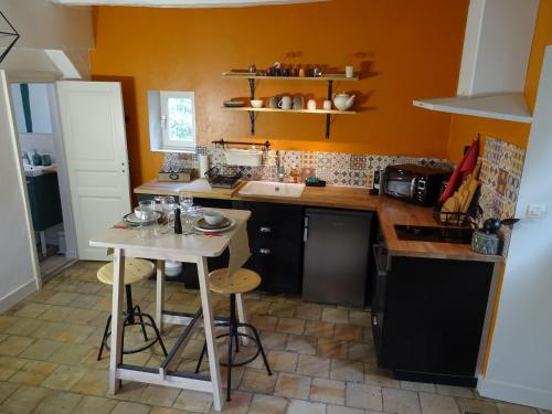 a small kitchen with a table and a sink at Les 3 échoppes in Chargé