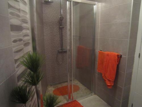 eine Dusche mit einem orangenen Handtuch im Bad in der Unterkunft Parque Santiago 2 - Casa del Sol in Playa de las Americas