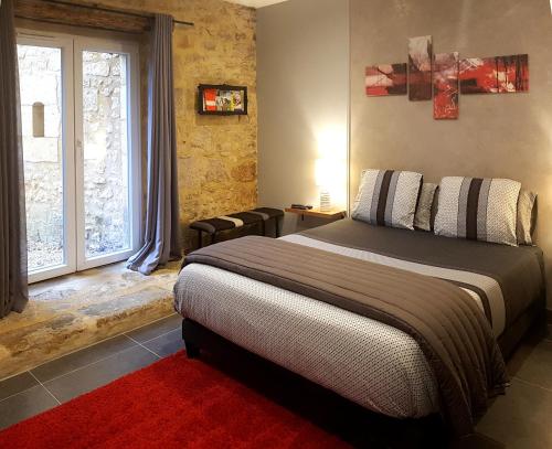 Un dormitorio con una cama grande y una ventana en Le Clos de la Canéda, en Sarlat-la-Canéda