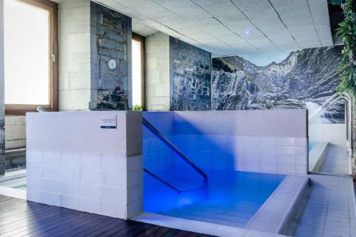 a swimming pool in a building with a mural on the wall at Hotel Balneario Orduña Plaza in Orduña