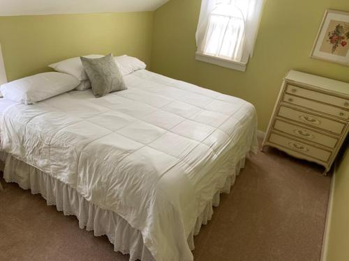 a bedroom with a large white bed and a dresser at Wiley Inn in Peru