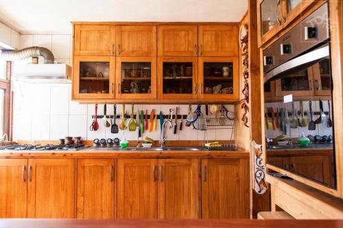 Una cocina con gabinetes de madera y un fregadero. en Refugio Guanay, en Constitución