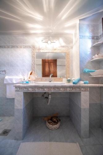 a bathroom with a sink and a mirror at Secret Paradise Beach Villa in Kalymnos