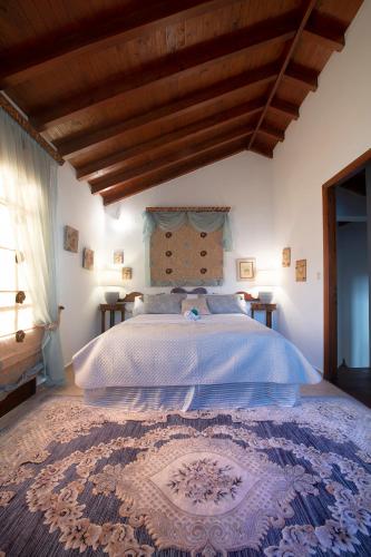 a bedroom with a large bed with a blue comforter at Secret Paradise Beach Villa in Kalymnos