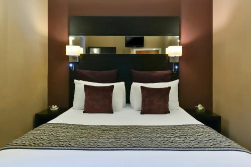 a bedroom with a large bed with two pillows at Fraser Suites Glasgow in Glasgow