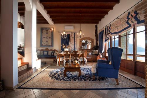 カリムノスにあるSecret Paradise Beach Villaのリビングルーム(テーブル、青い椅子付)