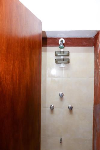 a bathroom with a wooden door and some towels at Hotel y Hostal Casa Don Alfonso in Valladolid