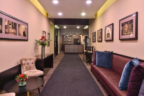 a waiting room with a couch and chairs and a counter at Fraser Suites Glasgow in Glasgow