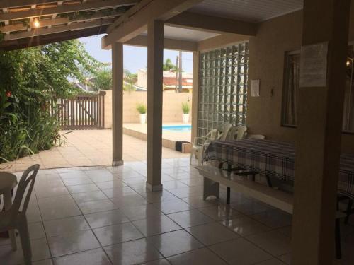a porch with a bed and a patio with a pool at Casas da Jaci in Guaratuba