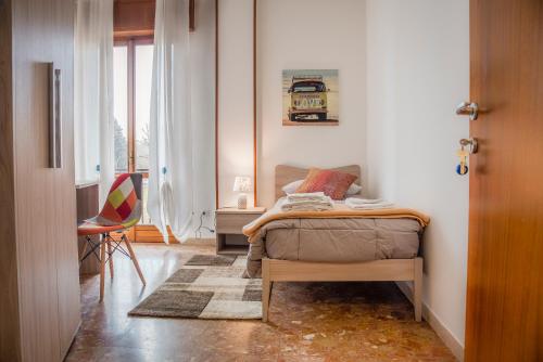a bedroom with a bed and a chair and a window at Gabrielli Rooms & Apartments - MARONCELLI in Verona