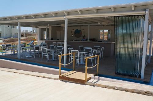 a patio with tables and chairs on a roof at Sun and Moon Villas in Aliko Beach