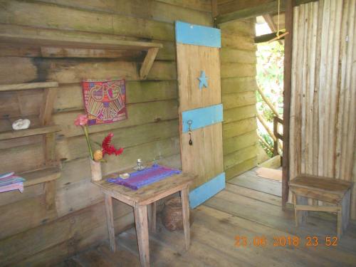 a wooden cabin with a table and a door at Posada Villamaga in El Valle