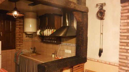 uma cozinha com um lavatório e um fogão forno superior em Casa Rural La Ossa em Ossa de Montiel