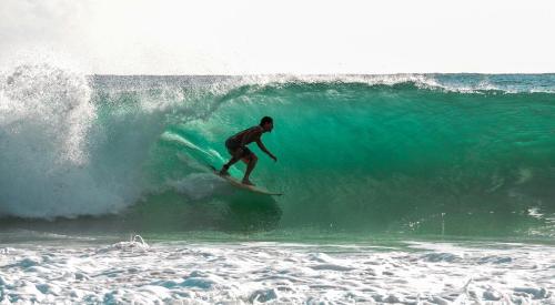 a man riding a wave on a surfboard in the ocean at Playa Bluff Lodge in Bocas del Toro