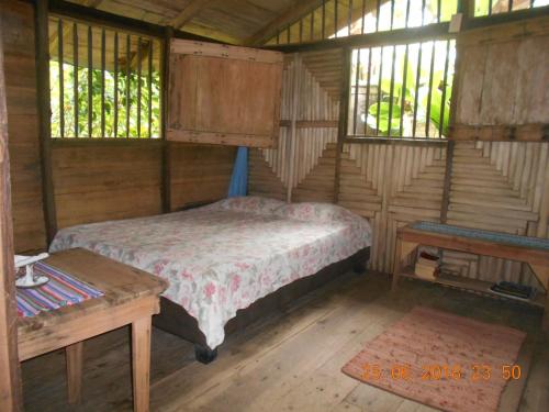 a bedroom with a bed and a table and windows at Posada Villamaga in El Valle