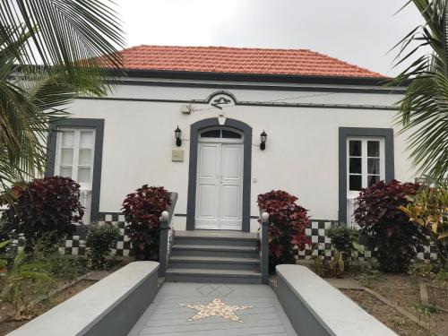 ein weißes Haus mit einer blauen Tür und einer Treppe in der Unterkunft Villa Vicente in Vila Nova Sintra