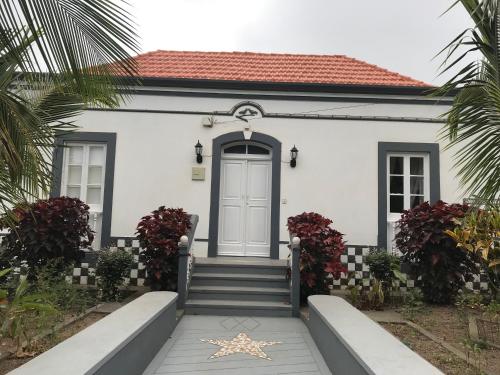 a white house with a blue door and stairs at Villa Vicente in Vila Nova Sintra