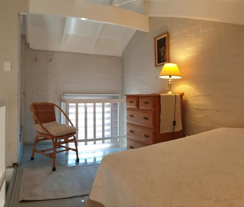 Un dormitorio con una cama, una silla y una lámpara. en Dawn's Place, en Strand