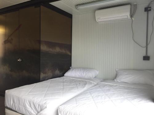 a bedroom with a white bed and a fan at Surfari Punta Rocas in Punta Negra