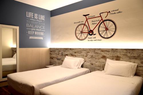 a room with two beds and a bike on the wall at Best Western Plus Soave Hotel in San Bonifacio
