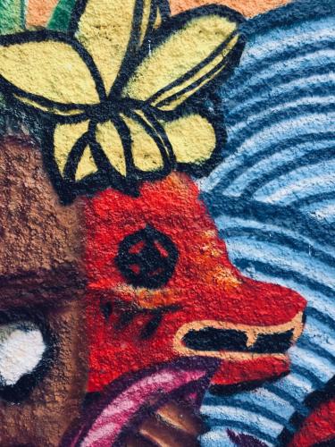 a painting of a red bear with a flower on its head at Surfari Punta Rocas in Punta Negra