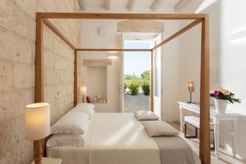a bedroom with a bed and a window at Masseria Mongiò dell'Elefante in Otranto