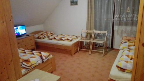a small room with two beds and a television at Pod Smrcinou in Nová Pec