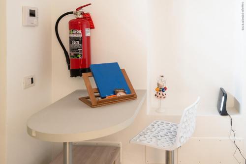 a white table with a fire hydrant and a chair at La Meridiana in Piacenza