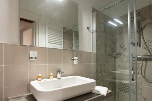 a bathroom with a white sink and a shower at La Meridiana in Piacenza