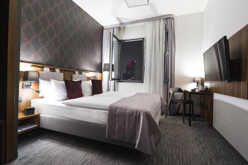 a hotel room with a bed and a desk at Best Western Hotel Mariacki Katowice in Katowice