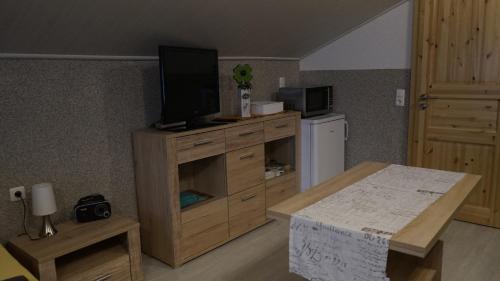 ein Wohnzimmer mit einem TV auf einem Holzschrank in der Unterkunft Pension im Glück Thale in Thale