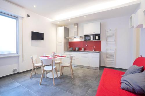 a living room with a table and chairs and a kitchen at Excelsior in Piombino