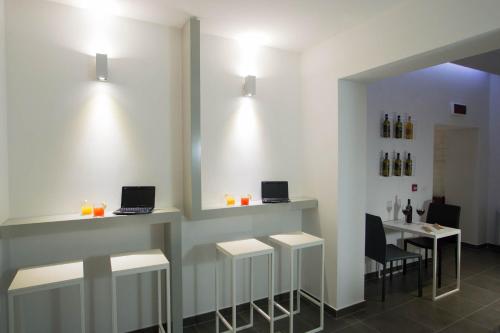 a bar with three stools and two laptops on the wall at Hotel Santa Brigida in Naples
