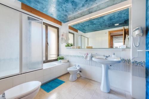ポルト・ダ・ポリェンサにあるAncora Apartmentの青い天井のバスルーム(洗面台、トイレ付)