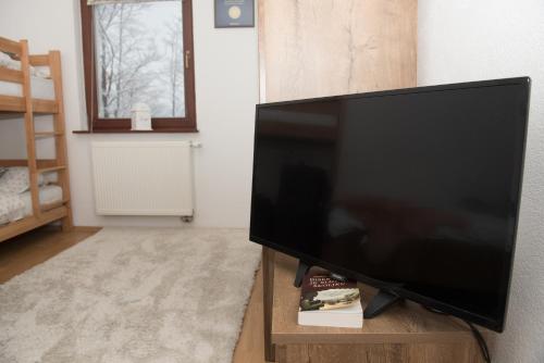 a flat screen tv sitting on a wooden stand in a living room at Apartment Hobbit - Bjelašnica in Bjelašnica