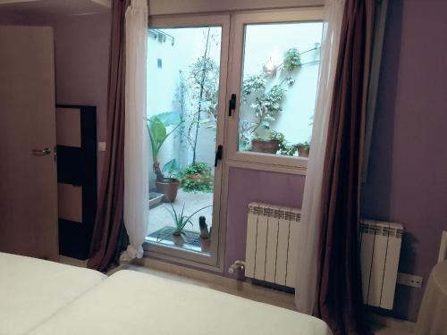 サラゴサにあるApartamento Teatro del Mercadoのベッドルーム1室(庭園の景色を望む窓付)