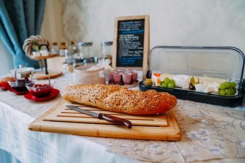 una pagnotta di pane su un tagliere con un coltello di Hotel Haus Singer a Wittenberge