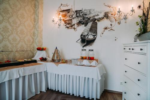 una stanza con due tavoli con tovaglia bianca di Hotel Haus Singer a Wittenberge