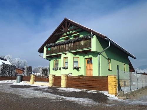 a green house with a balcony on top of it at Apartmán Klaudia in Ružomberok