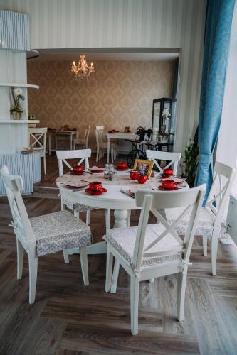 a white table and chairs with red plates on it at Hotel Haus Singer in Wittenberge