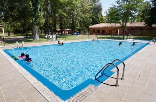 een groep mensen in een groot zwembad bij Camping Fuentes Blancas in Burgos